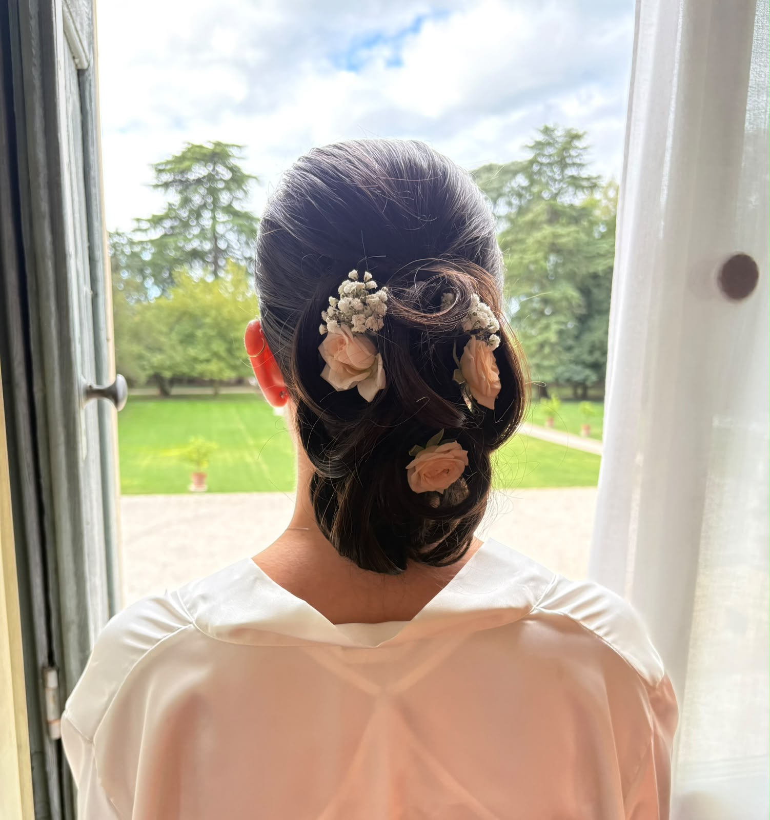 Acconciatura da sposa con fiori realizzata da Moovie Parrucchieri